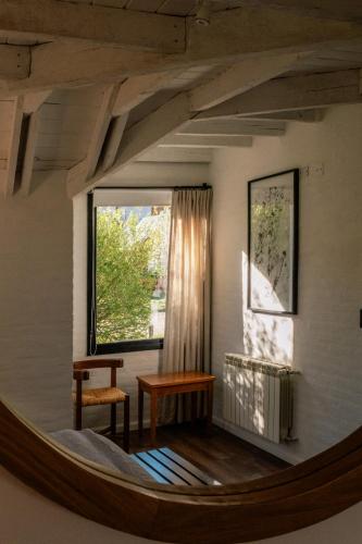 a living room with a large window and a table at Hosteria El Puma in El Chalten