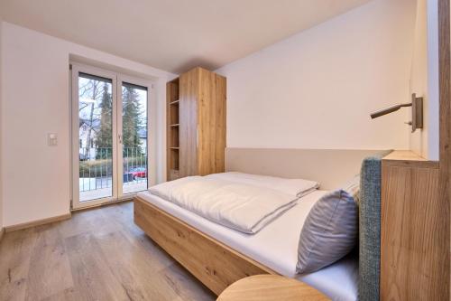 a bedroom with a bed and a window at Starnberger See Apartments in Starnberg