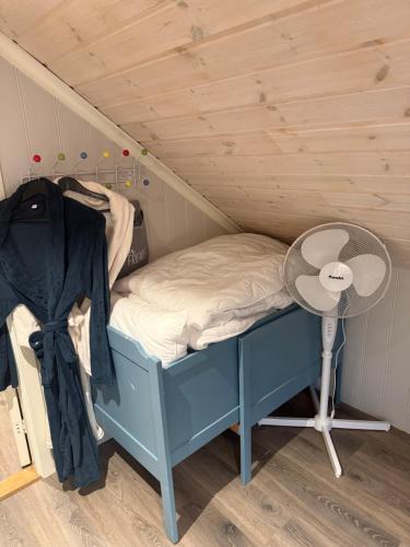 a small bed in a room with a fan at Rosenli Gård in Tønsberg