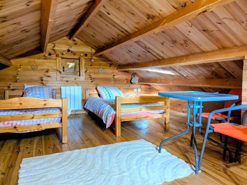 a log cabin with a bed and a table at " domaine des chevrettes chalet cosy au cœur des châteaux " in Cour-Cheverny