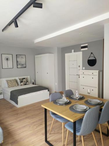 a bedroom with a bed and a table and chairs at Студио Ирма in Burgas