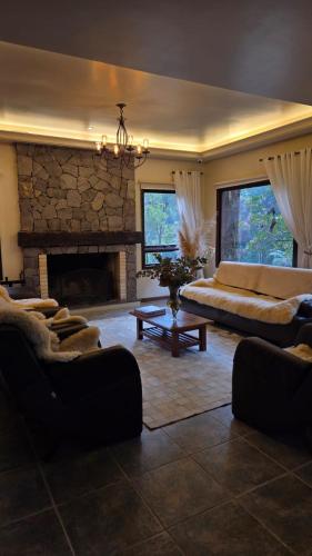 a living room with a couch and a fireplace at Pousada Pinhão e Poesia in Canela