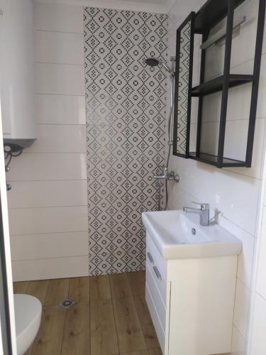 a bathroom with a sink and a toilet and a mirror at Студио Ирма in Burgas