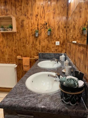 a bathroom with two sinks and a granite counter top at ferme des grands blaise in La Bresse
