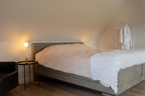 a bedroom with a bed with a white comforter at B&B de Gouden Ploeg met Jacuzzi in Bergentheim