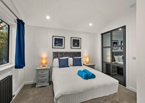 a bedroom with a bed with a blue pillow on it at Finest Retreats - Silverwood Premium Chalet in Errol