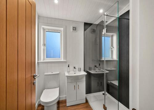 a bathroom with a toilet and a sink and a shower at Finest Retreats - Silverwood Premium Chalet in Errol