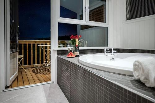 a bathroom with a bath tub and a sink at Finest Retreats - Silverwood Spa Lodge in Errol