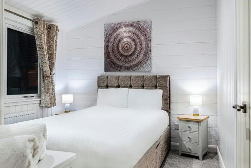 a white bedroom with a large bed and a window at Finest Retreats - Silverwood Spa Lodge in Errol