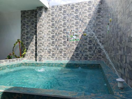 a swimming pool in a room with a stone wall at VaRI in Tocaima