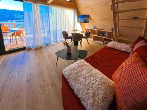 a living room with a bed and a table with a view at Les Terrasses du Grillon in Chambon-sur-Lac