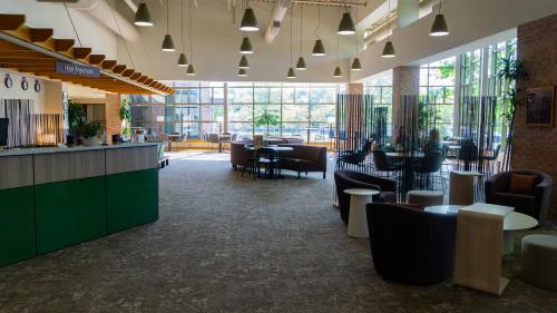 a lobby of a restaurant with tables and chairs at Prince Conference Center & Hotel in Grand Rapids