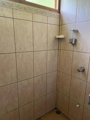 a bathroom with a tiled shower with a window at Cabañas Luz de Luna in Llano Grande