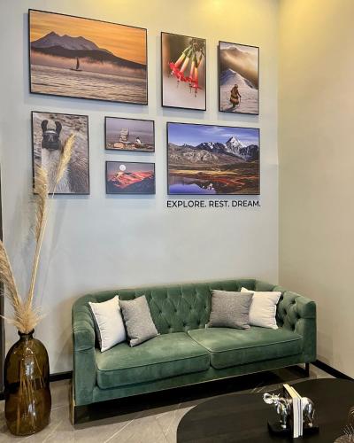 ein Wohnzimmer mit einer grünen Couch und Bildern an der Wand in der Unterkunft DREAM By Stannum Hotel in La Paz