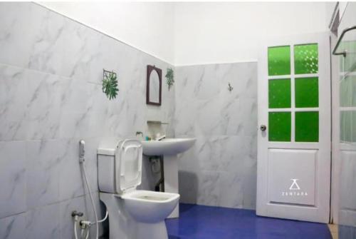 a bathroom with a toilet and a sink and a door at Happy Laugh Ella in Ella
