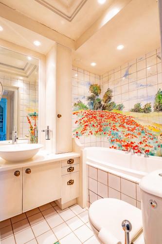 a bathroom with a large painting of flowers on the wall at Château de Bissieux in Châtillon-sur-Chalaronne