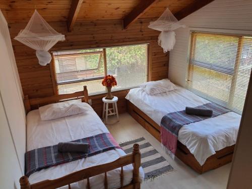 a bedroom with two beds in a log cabin at Log Cabin- Forest, Lagoon Sea location in Hermanus