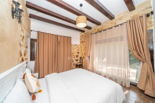 a bedroom with a white bed and a window at Charming villa with pool and unobstructed view in Tangier