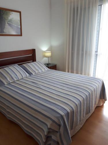 a bedroom with a large bed with a striped blanket at Alfonsina 2 in Colón