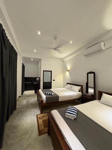 a hotel room with two beds in a room at The Rosemary House in Weligama