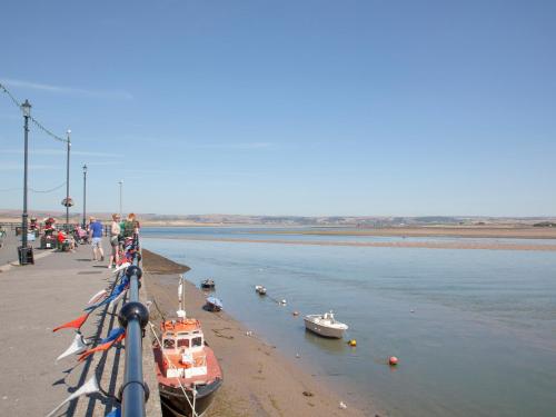 a group of people standing on a dock with boats in the water at Tillerman Cottage Appledore Devon in Appledore