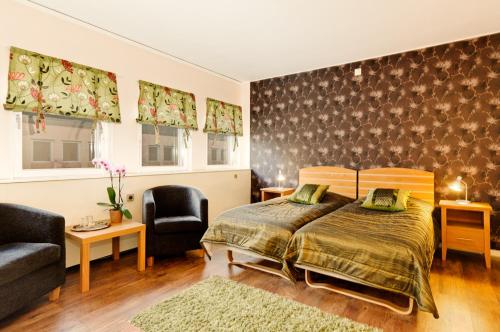 - une chambre avec un lit, un canapé et des chaises dans l'établissement Hotell City, à Härnösand