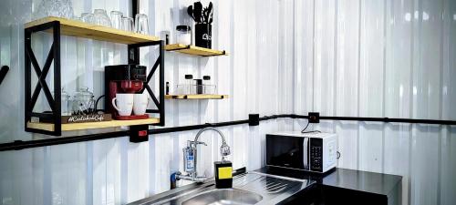 a kitchen counter with a sink and a microwave at Refúgio Aconchegante in São Sebastião
