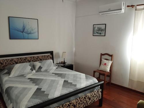 a bedroom with a bed and a chair at Casa Rebelo in Cossourado