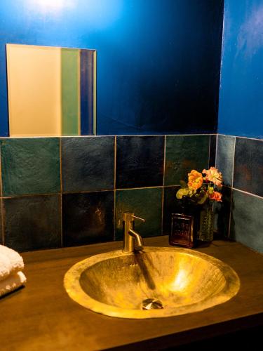 a sink in a bathroom with a vase of flowers at Maison Bonnefoy Toulouse in Toulouse