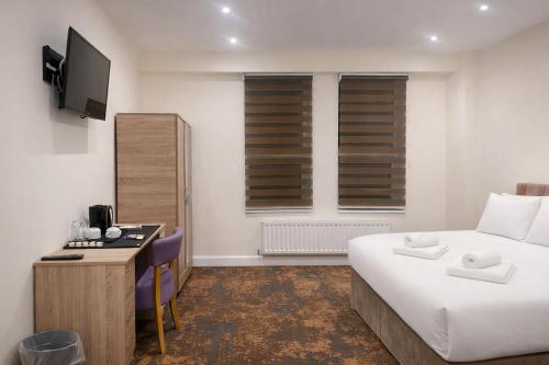 a hotel room with a bed and a desk with a computer at The Miles Arms Hotel in Avonmouth