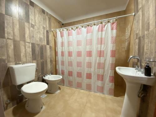 a bathroom with a toilet and a sink at La Esquina en el Rio in Paraná