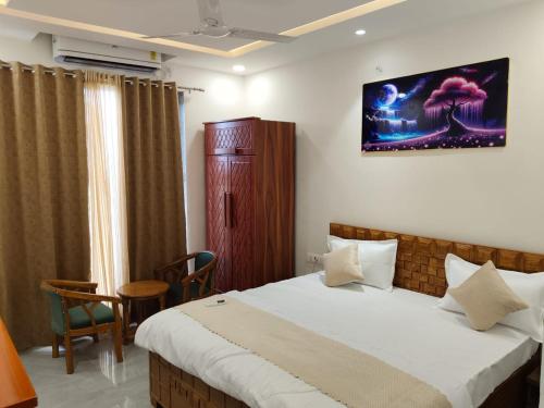 a bedroom with a bed and a table and chairs at Aadhya Hotel & Adhira Restaurant in Orchha