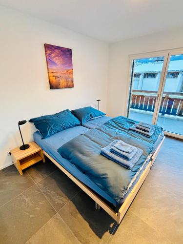 a large bed in a room with a large window at Brand-New Eiger View 3BR Apartment - Premium Location - Free Parking - Terrace in Grindelwald