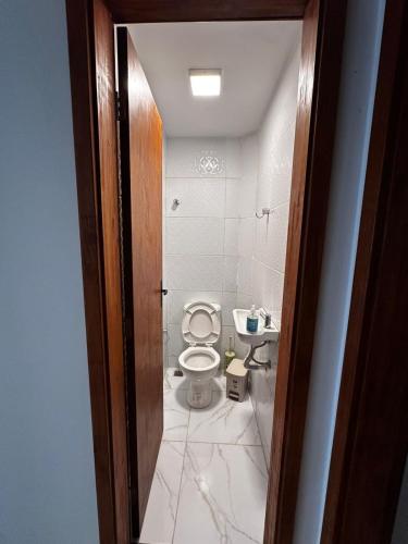 a bathroom with a toilet and a sink at Village com 2 suites com ar a 300mts da praia e do rio in Mata de Sao Joao