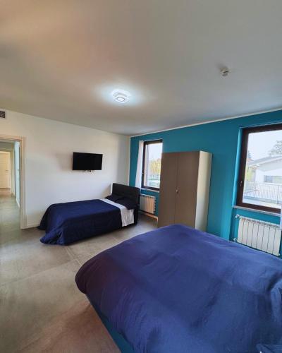 a bedroom with two beds and a blue wall at GC Petit Palais in Gallarate
