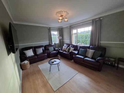a living room with leather couches and a table at Fjell2Sea in Newcastle