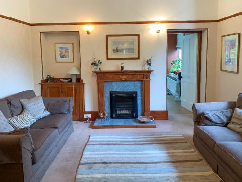 a living room with two couches and a fireplace at The Coyles - Uk31466 in Ballater