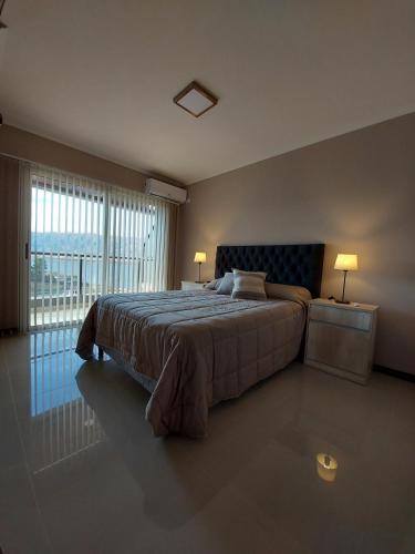 a bedroom with a bed and a large window at Veneto Village in Villa Parque Siquiman