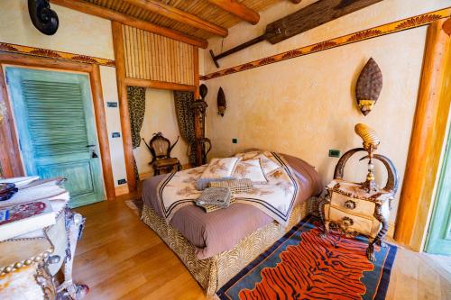 a bedroom with a bed and a table with a suitcase at Château de Bissieux in Châtillon-sur-Chalaronne