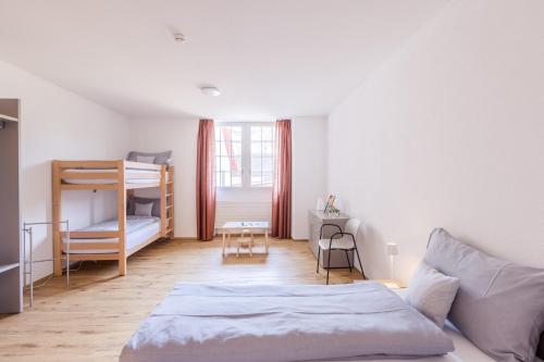 a bedroom with a bed and a bunk bed at Bed and Breakfast Kloster Frienisberg in Seedorf