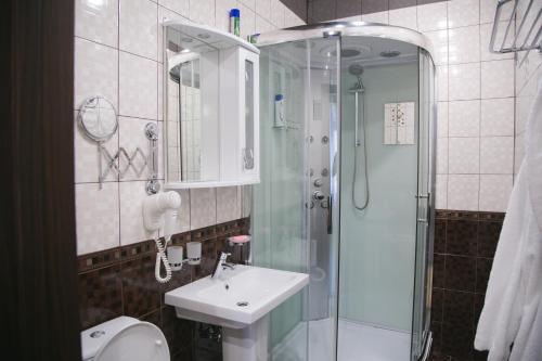 a bathroom with a shower and a sink and a toilet at Hotel Yunost in Yekaterinburg