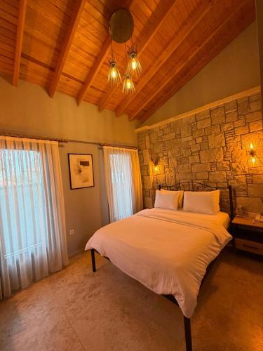 a bedroom with a bed and a stone wall at LUTA Urla in Urla