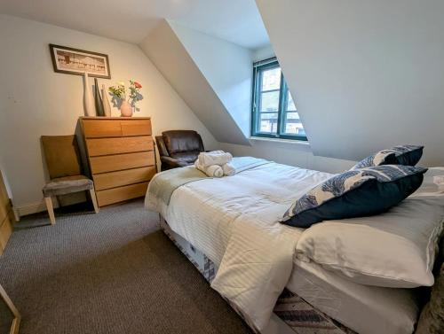 a bedroom with a bed with a chair and a dresser at City Center Gem-4Bd House! in Edinburgh