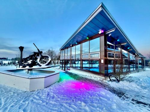 a building in the snow with a motorcycle in it at Der schöne Asten - Resort Winterberg in Winterberg