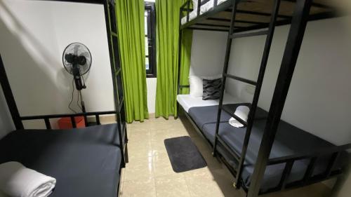 a room with two bunk beds with green curtains at Friendship Villa-Ella in Nikawatawana
