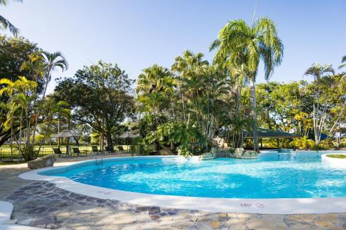 ein Swimmingpool in einem Resort mit Palmen in der Unterkunft Blue JackTar in San Felipe de Puerto Plata