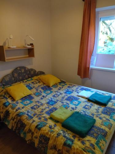 a bedroom with a bed with green pillows on it at Babarczi Üdülőház in Kiskunmajsa