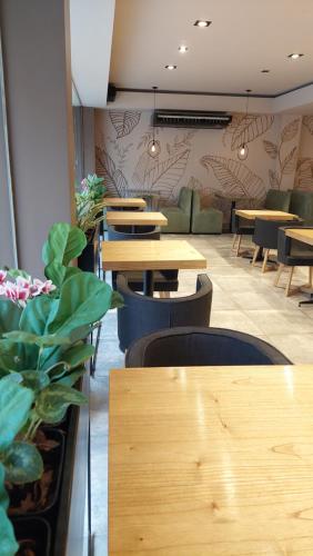 a restaurant with wooden tables and chairs and plants at HDA Miraflores in Termas de Río Hondo