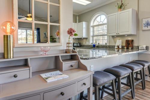 a kitchen with white cabinets and bar stools at Golf, Gamble and Fish! Condo with Pool in Little River in Little River