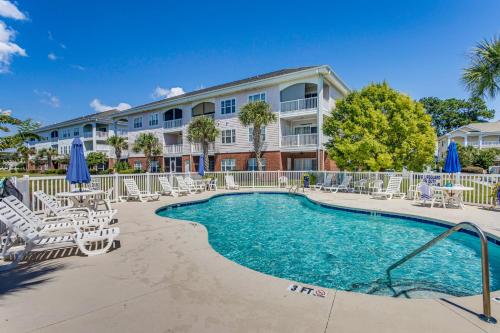 a resort with a swimming pool and chairs and a building at Golf, Gamble and Fish! Condo with Pool in Little River in Little River